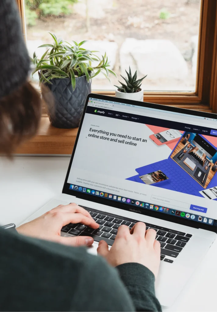 Person working on a laptop with an online store on screen